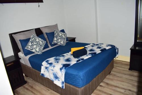 a bed with blue and white sheets and pillows at City Centre Self-Catering Suites in Windhoek