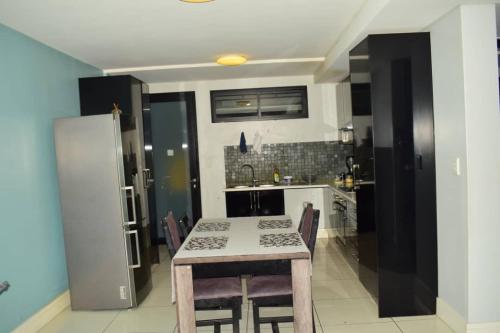 a kitchen with a table with chairs and a refrigerator at City Centre Self-Catering Suites in Windhoek