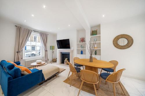 a living room with a blue couch and a table at New stylish 3-Bed Pimlico House near Big Ben in London