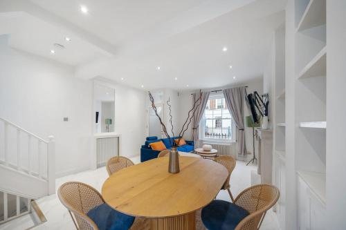 a dining room with a wooden table and chairs at New stylish 3-Bed Pimlico House near Big Ben in London