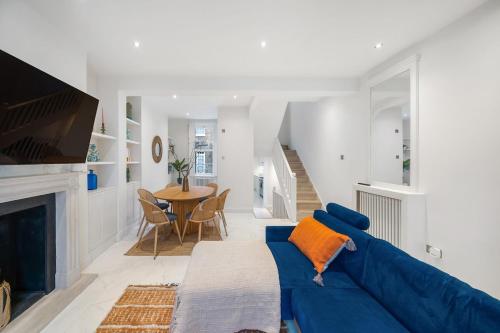a living room with a blue couch and a table at New stylish 3-Bed Pimlico House near Big Ben in London