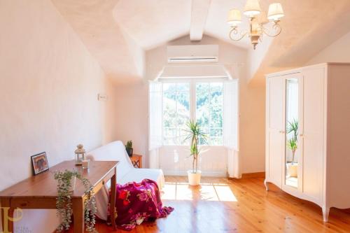 a living room with a white couch and a table at Window to the Valley in Santo Isidoro