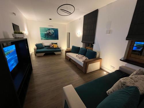 a living room with a couch and a tv at Wooden House near City center in Rīga