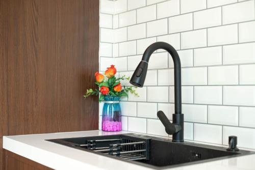 a kitchen sink with a vase with flowers in it at De Beach pool villa เดิน 3 นาทีจากชายหาด in Jomtien Beach