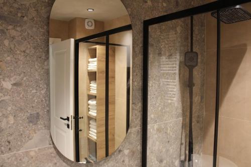 a bathroom with a mirror and a walk in shower at Sun Apartments in Pristina