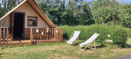 - deux chaises assises devant une cabine dans l'établissement Camping Onlycamp Sous les Pommiers, à Trévières
