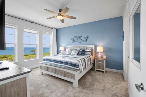 Un dormitorio con una cama con paredes y ventanas azules. en The Sunset Retreat at One Particular Harbour 384-202, en Bradenton