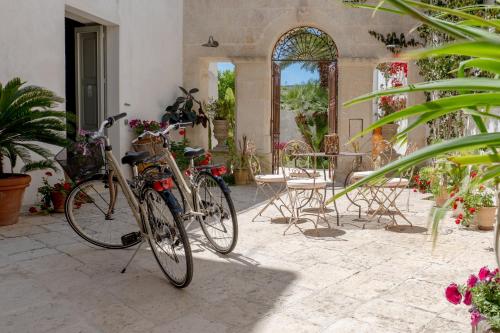two bikes parked in a patio with a table and chairs at Palazzo Angelica - Luxury Retreat Otranto in Giurdignano