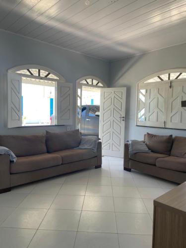 ein Wohnzimmer mit 2 Sofas und 2 Fenstern in der Unterkunft Casa de praia No Abais in Praia Da Caueira