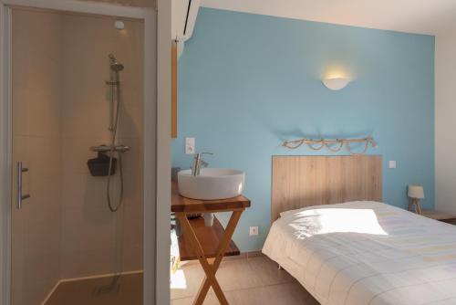 a bathroom with a bed and a sink and a shower at Le Chalet des Retrouvailles in Sers