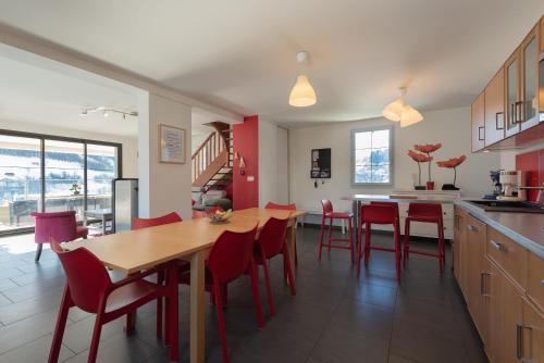 a kitchen with a wooden table and red chairs at Le Chalet des Retrouvailles in Sers