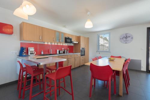 a kitchen with red chairs and a table at Le Chalet des Retrouvailles in Sers