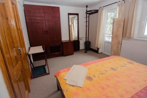 a bedroom with a bed and a chair and a window at Penzion Betlém in Janske Lazne