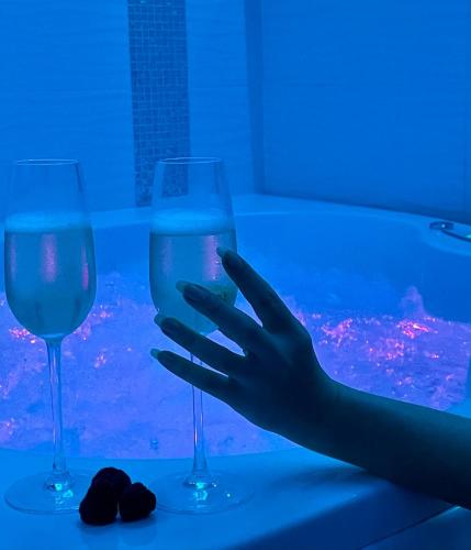 une main tendue pour un verre de vin sur une table dans l'établissement Maison de Monplaisir Love Room - Lyon, à Villeurbanne