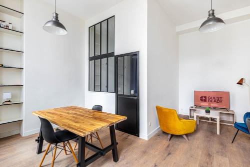 une salle à manger avec une table et des chaises en bois dans l'établissement GuestReady - Comfortable retreat in the 11th Arr, à Paris