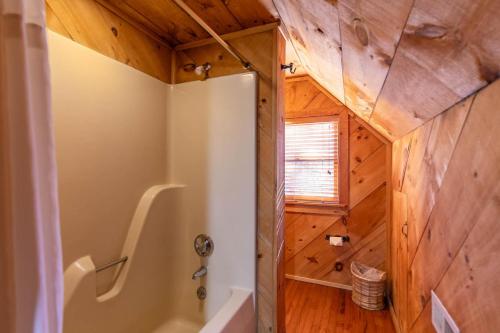 a bathroom with a tub and wooden walls at A River Runs Through It in Valle Crucis