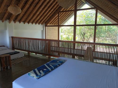 a room with a bed and a large window at Casa Flora Ayampe in Ayampe