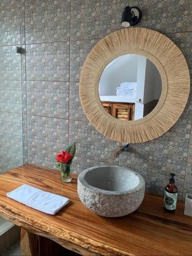 a bathroom with a stone sink and a mirror at Casa Flora Ayampe in Ayampe