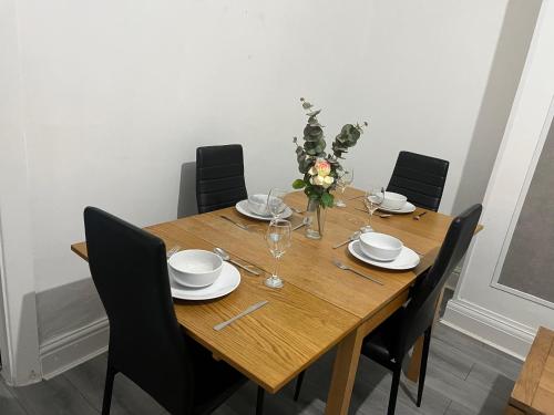 a wooden dining room table with black chairs and a wooden table at Alton House in Hollinwood