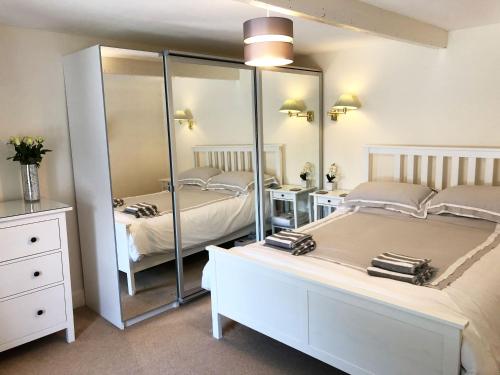 a bedroom with two beds and a large mirror at White Lion Aberporth in Aberporth