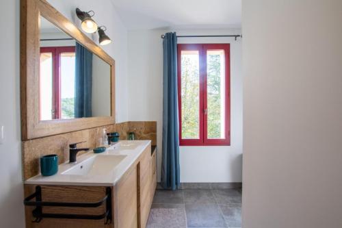 une salle de bain avec un lavabo et un miroir dans l'établissement Chantegrel, à Auriac-du-Périgord
