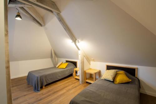 Cette chambre mansardée comprend deux lits et un escalier. dans l'établissement Chantegrel, à Auriac-du-Périgord