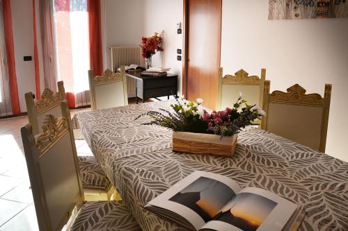 a table with a book on it with flowers on it at Affitto breve Bassano del Grappa Casa Corrado in Cassola
