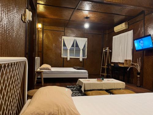 a room with two beds and a tv in it at Once in Lampang Guesthouse in Lampang
