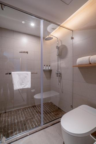 a bathroom with a shower and a toilet at Zhangjiajie Homeinn Plus Hotel in Zhangjiajie