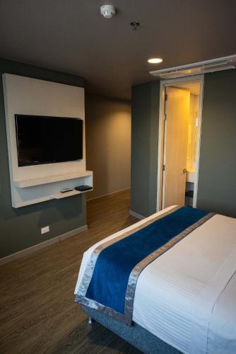 a bedroom with a bed and a flat screen tv at Hotel Black Tower Premium in Bogotá