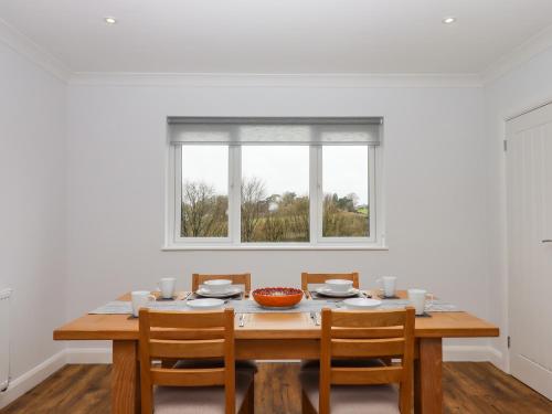 a dining room table with chairs and a window at West View in Okehampton