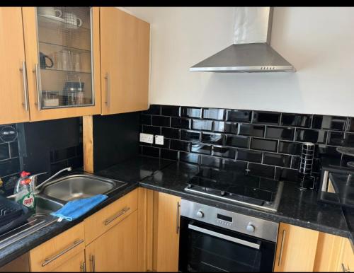 a kitchen with a sink and a stove top oven at London House near Greenwich, Free Parking, Free WIFI in London