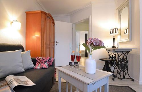 a living room with a couch and wine glasses on a table at Appartement-Villa Steinfurth in Binz