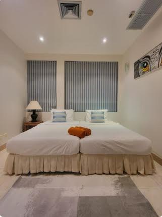 a bedroom with a large bed with white sheets and blue pillows at Heavenly place in Surin Beach