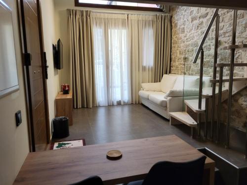 a living room with a white couch and a brick wall at 1929 Boutique Residences in Ioannina
