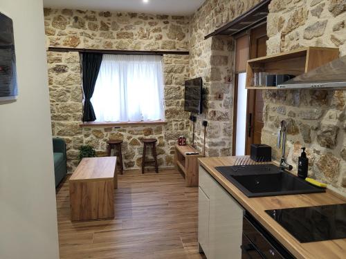 a kitchen and living room with a stone wall at 1929 Boutique Residences in Ioannina