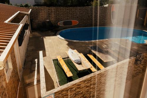 an overhead view of a swimming pool with a table and chairs at Lisbon Surf Hostel in Carcavelos