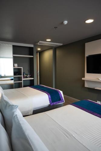 a bedroom with two beds and a flat screen tv at Hotel Black Tower Premium in Bogotá