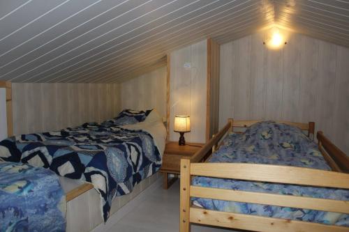 une chambre avec deux lits et une lampe sur une table dans l'établissement SP280-1142 Appartement 2 pièces - mezzanine SAINT PIERRE LA MER, à Saint Pierre La Mer