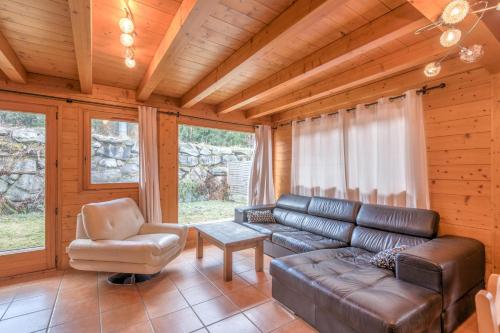 - un salon avec un canapé en cuir et une chaise dans l'établissement Chalet Hideaway 1 - Welkeys, à Chamonix-Mont-Blanc