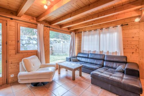- un salon avec un canapé en cuir et une chaise dans l'établissement Chalet Hideaway 1 - Welkeys, à Chamonix-Mont-Blanc