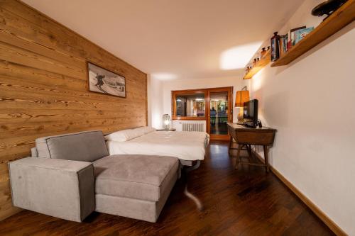 a bedroom with a bed and a couch and a chair at Appartamento Prestige in Sestriere