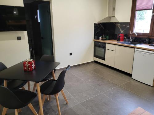 a kitchen with a black table and some chairs at 1929 Boutique Residences in Ioannina