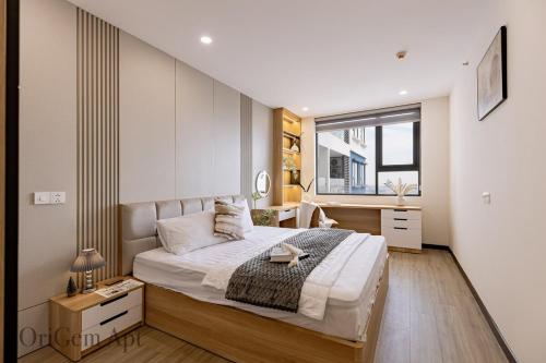 een slaapkamer met een groot bed en een bureau bij OriGem - Skyview Căn Hộ 2 PN in Thu Dau Mot
