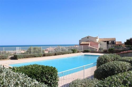 une grande piscine avec l'océan en arrière-plan dans l'établissement SP520-G007 Appartement 2 pièces SAINT PIERRE LA MER, à Saint Pierre La Mer