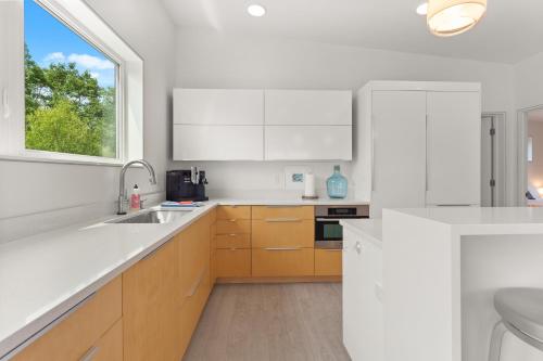 a white kitchen with a sink and a window at Private Oasis easy access to Park and Town in Bar Harbor