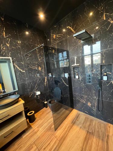 Un baño con ducha con paredes de mármol negro. en Wenceslas square apartment 150 m2, en Praga
