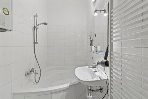 3 Minutes to Metro I At Gürtel I Fast Wifi في فيينا: حمام أبيض مع حوض وحوض استحمام