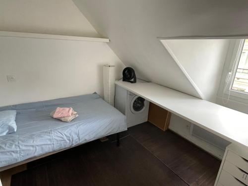 une petite chambre avec un lit et une fenêtre dans l'établissement Appartement Atypique, centre de Paris, à Paris