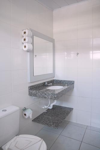 a white bathroom with a sink and a mirror at Pousada Schmitz in Florianópolis